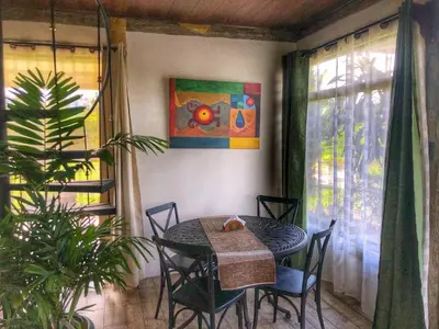 a dining room table with chairs and a painting on the wall at Villa Tucan in Agua Azul