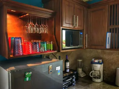 a kitchen with a refrigerator and wooden cabinets at Villa Tucan in Agua Azul