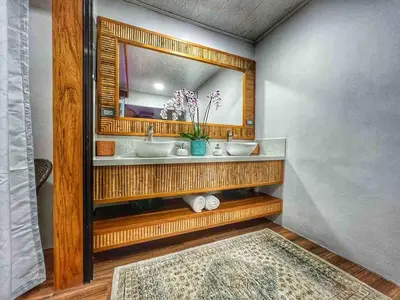 a bathroom with two sinks and a mirror at Sassy Sloth Villa in Fortuna