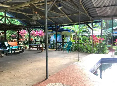 a patio with a table and chairs and a pool at Ojochal, Costa Rica artist owned property in Ciudad Cortés