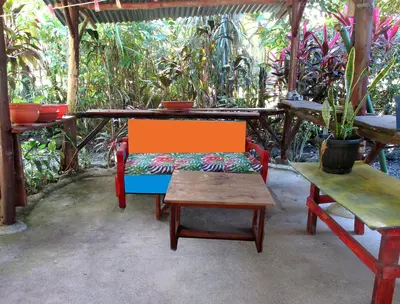 a table with a bench and a table with a chair at Ojochal, Costa Rica artist owned property in Ciudad Cortés