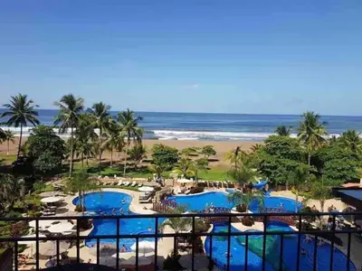 a view of the beach from the balcony of a resort at 2 Bedroom Condo in Croc's Casino Resort in Jacó