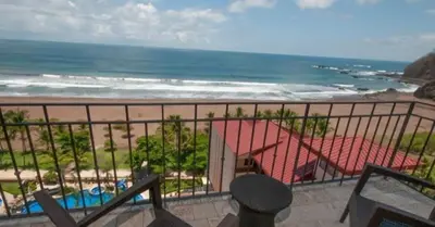 a balcony with a view of the beach at 2 Bedroom Condo in Croc's Casino Resort in Jacó