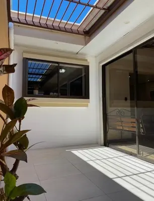 an open glass door of a house with a patio at Casa cerca Aeropuerto in Tapantí