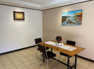 a dining room table with chairs and a painting on the wall at Casa cerca Aeropuerto in Tapantí