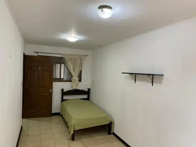 a small bedroom with a bed and a window at Casa cerca Aeropuerto in Tapantí