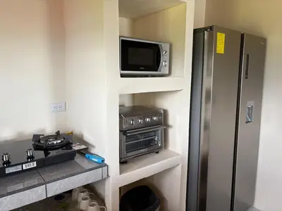 a small kitchen with a refrigerator and a tv at Cabin Casove in El Castillo de La Fortuna