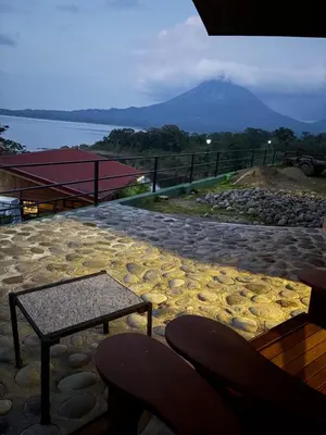 a stone patio with a table and a mountain in the background at Cabin Casove in El Castillo de La Fortuna