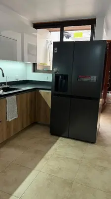 a black refrigerator in the middle of a kitchen at Habitación Sabana Norte 200m Estadio Nacional San José in San José