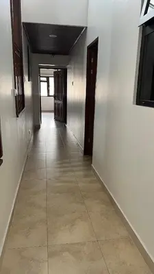 an empty hallway with white walls and a tile floor at Habitación Sabana Norte 200m Estadio Nacional San José in San José