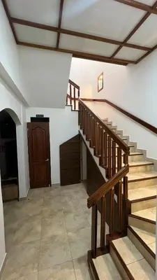 a staircase in a house with wooden railings at Habitación Sabana Norte 200m Estadio Nacional San José in San José