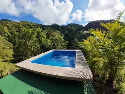 a swimming pool on the side of a house at Cabaña Brisas Del Río in Parrita