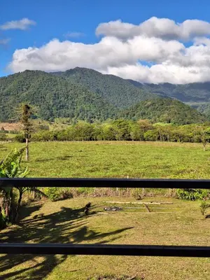 a view of a field with mountains in the background at Cabaña Cherenga in Sarchí