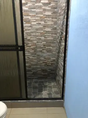 a bathroom with a shower with a brick wall at Apartment near from Airport in Guardia