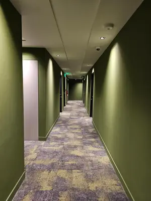 a hallway with green walls and a long corridor at 11th Floor Apartment with Sabana View Fast WiFi and AC in San José