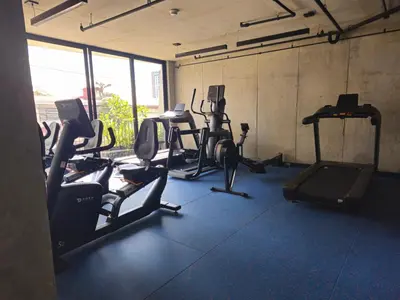 a gym with several treadmills and exercise bikes at 11th Floor Apartment with Sabana View Fast WiFi and AC in San José