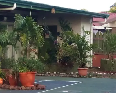 a tennis court in front of a house with plants at Hotel casa yayaz Nature Lodge in Grecia