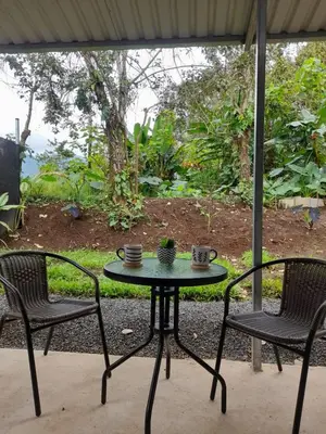 a patio table with two chairs and a table with cups at La casita de chelo in Fortuna