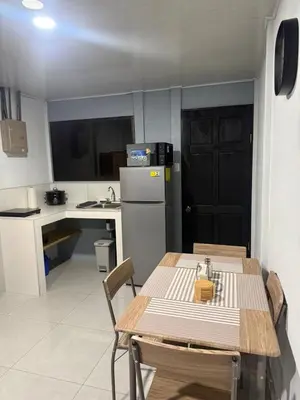 a small kitchen with a table and a refrigerator at La casita de chelo in Fortuna