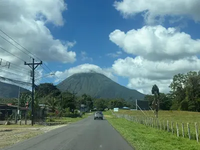 a car driving down a road in front of a mountain at La casita de chelo in Fortuna