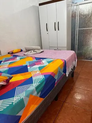 a bed in a room with a colorful blanket on it at GuestHouse Detours CR in Fortuna