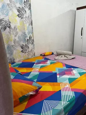 a bed with a colorful blanket and pillows on it at GuestHouse Detours CR in Fortuna