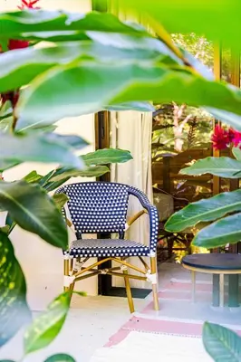 a blue chair sitting on a porch with plants at Pelada Jungle Nest 5-Min Walk to Beach & River in Nosara