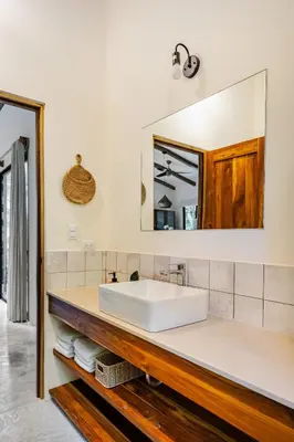 a bathroom with a white sink and a mirror at Pelada Jungle Nest 5-Min Walk to Beach & River in Nosara