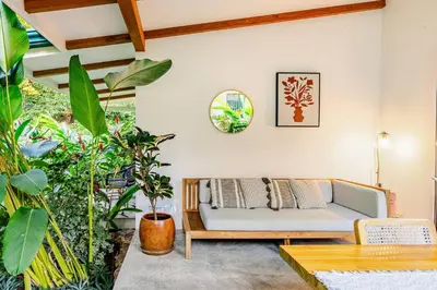 a living room with a couch and some plants at Pelada Jungle Nest 5-Min Walk to Beach & River in Nosara