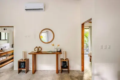 a living room with a table and a mirror at Pelada Jungle Nest 5-Min Walk to Beach & River in Nosara
