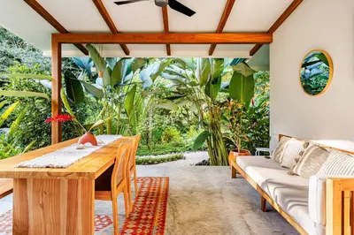 a living room with a table and a couch at Pelada Jungle Nest 5-Min Walk to Beach & River in Nosara