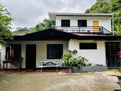 a white house with a picnic table in front of it at Casa Marisol in Quepos