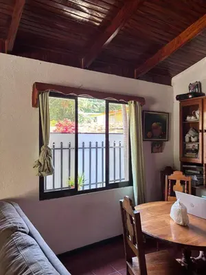 a living room with a table and a window at Casa Marisol in Quepos