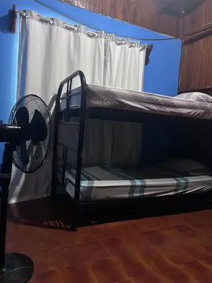 a bunk bed with a fan in a room at Casa Marisol in Quepos