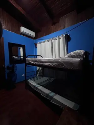 a room with two bunk beds and a blue wall at Casa Marisol in Quepos