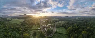 an aerial view of a forest with the sun setting at Tiny Homes Tamarindo in Tamarindo