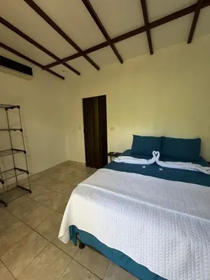 a bedroom with a bed with blue and white sheets at Green Lodge 2 in Toro Amarillo