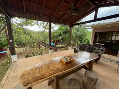 a wooden table on a patio with a couch at Pura Noche Guanacaste in Marbella