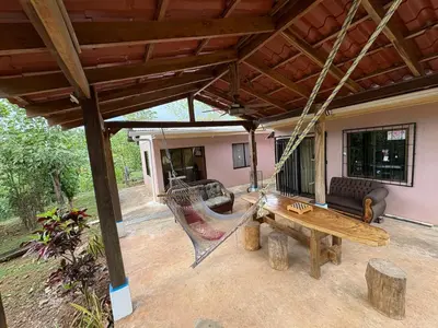 a porch with a hammock and a couch at Pura Noche Guanacaste in Marbella