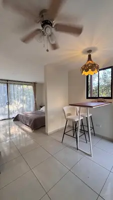 a living room with a ceiling fan and a table at Miles Away Boutique Villa in Cóbano