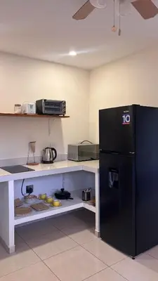 a kitchen with a black refrigerator in a room at Miles Away Boutique Villa in Cóbano