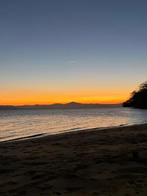 a beach with a sunset in the background at Beach house Punta Morales in Morales
