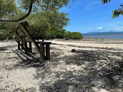a wooden bench sitting on a beach near the water at Beach house Punta Morales in Morales