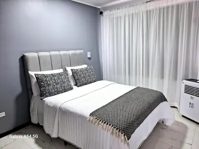 a bedroom with a bed with black and white pillows at Vistas del Sol-Apartamento Entero in Pedregoso