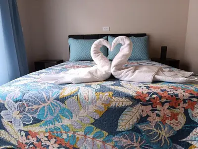 a bed with two towels in the shape of hearts at Casita Brisa Verde in Bijagua