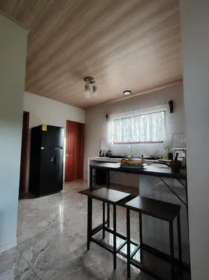 a kitchen with a counter and a black refrigerator at Casita Brisa Verde in Bijagua