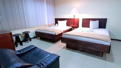 a hotel room with two beds and a couch at Hotel Ambassador in San José