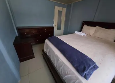 a bedroom with a large bed with a blue wall at Apartamento DesCANsO #1 in Palmira