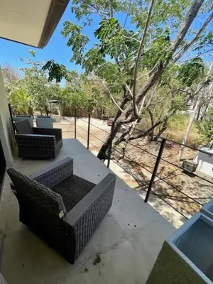 two wicker chairs sitting on the porch of a house at Langosta apartment in Tamarindo