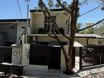 a building with a tree in front of it at Langosta apartment in Tamarindo